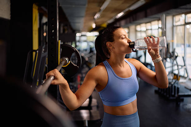 istock Thirsty athlete drinking water during her strength training in a gym. 2225261738