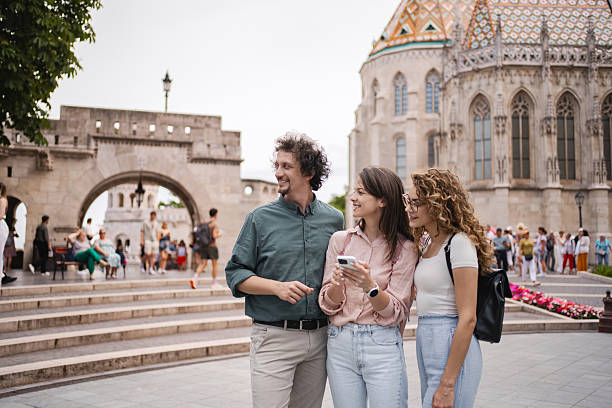 Group of tourists using smartphone app for visiting Matthias Church in Buda Castle, Budapest, Hungary