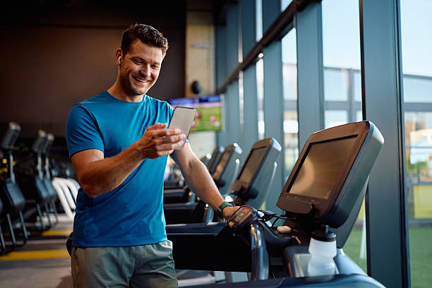 istock Happy sportsman text messaging on mobile phone while working out in a gym. 2225263344