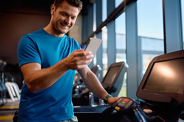 istock Happy athlete texting on cell phone while working out in a gym. 2225263372