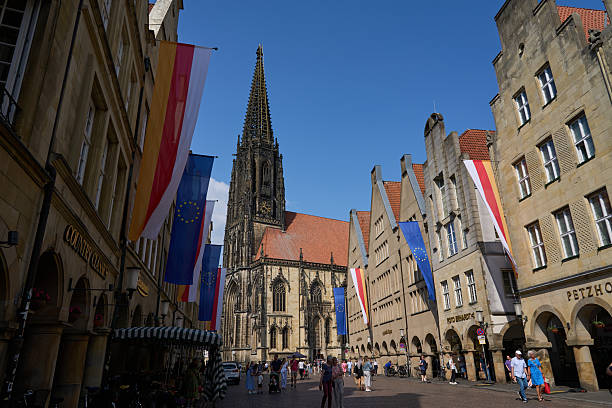Muenster, Germany -  May 2, 2025 - historical center of city - the historic principal marketplace - Prinzipalmarkt on a sunny spring day. The Prinzipalmarkt is the historic principal marketplace of Münster, Germany. It is shaped by historic buildings with picturesque pediments attached to one another. It extends from St. Lambert's Church (Lambertikirche) in the north to the Townhouse Tower (Stadthausturm) in the south and is home to luxurious shops and cafés.