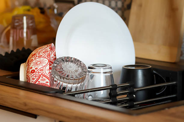 istock A bright kitchen background features a sparkling clean sink filled with fresh dishes, including a pristine plate, gleaming glass, and polished mug 2225268818