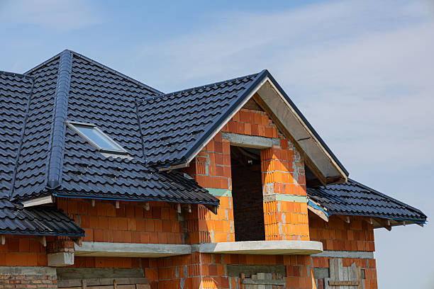 istock Metal tile roofing is being installed on a partially built house under a clear blue sky, showcasing modern construction techniques 2225270715