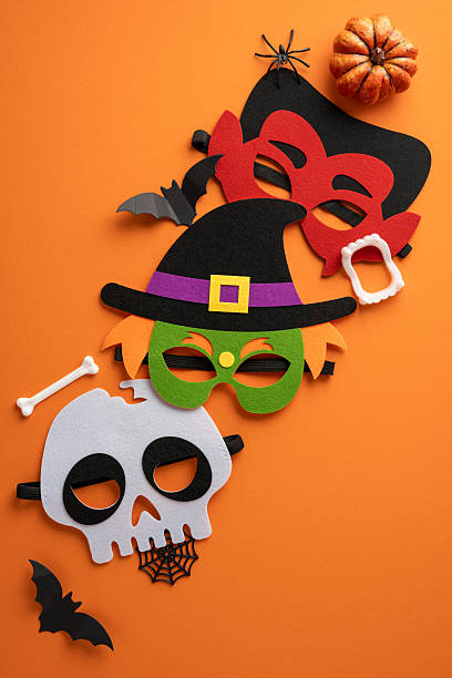 istock Various vertical decorative Halloween masks, a pumpkin, and paper bats create a festive atmosphere 2225270802