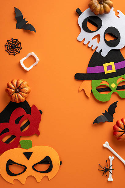 istock Vibrant vertical Halloween-themed composition featuring festive masks, pumpkins, bats, and spiderwebs on an orange backdrop creating a lively holiday atmosphere 2225270803