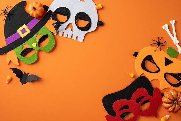 istock Halloween-themed flat lay featuring colorful masks and vibrant decorations arranged on an orange surface 2225270806