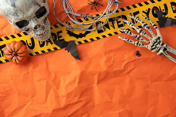 istock Halloween themed arrangement on orange background with creative elements including skull and skeleton hand 2225270838