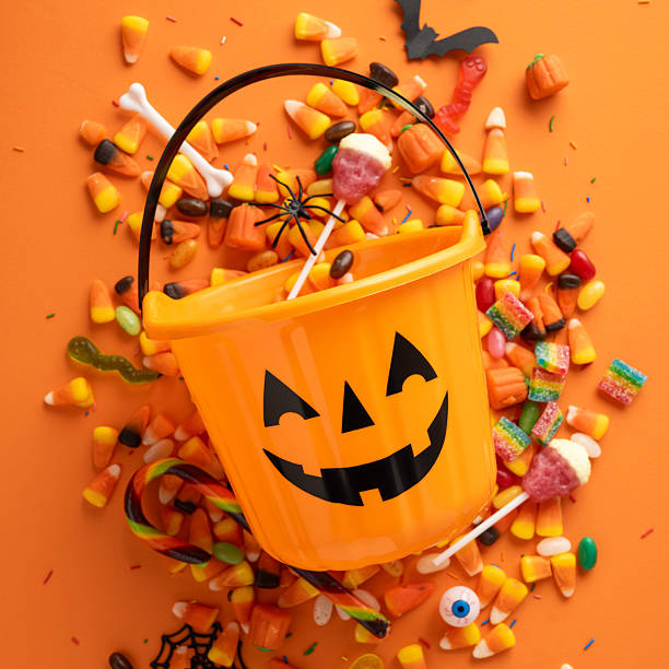 istock Halloween-themed vertical setup featuring a pumpkin bucket alongside festive candies and seasonal objects 2225270848