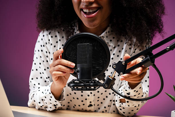 istock Smiling woman adjusting microphone and preparing for recording podcast selective focus 2225273489