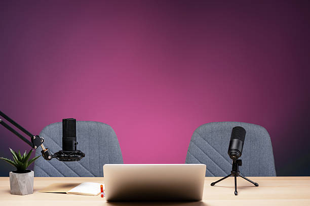 Podcast studio setup featuring microphones, laptop, and chairs ready for recording
