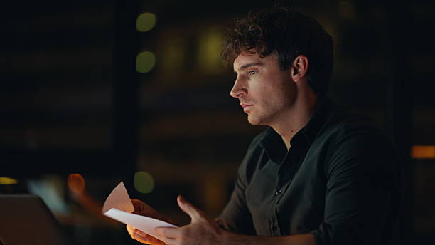 istock Tensed freelancer reading documents at dark workplace closeup. Worried man 2225274299