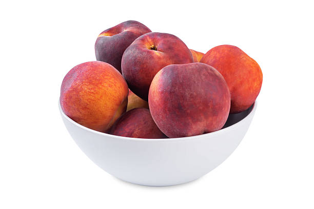 istock Fresh raw peaches in a white bowl on a white isolated background 2225274748