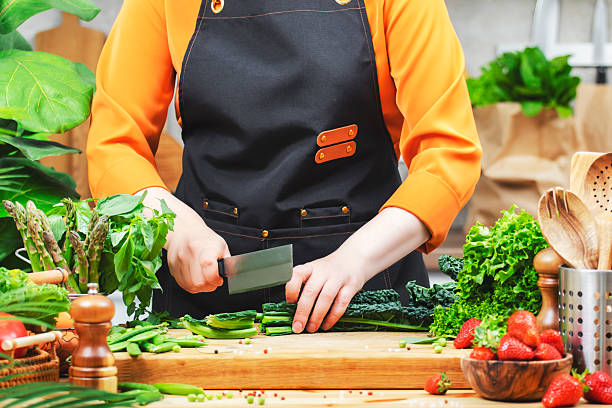 Cooking healthy vegan dishes with fresh vegetables in a bright kitchen setting by a passionate female chef