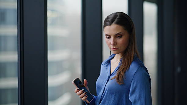 istock Corporate worker looking window office building holding smartphone closeup. 2225284331