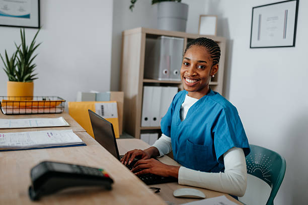 istock Nurse posing for camera while sitting at the reception counter at the hospital 2225284551
