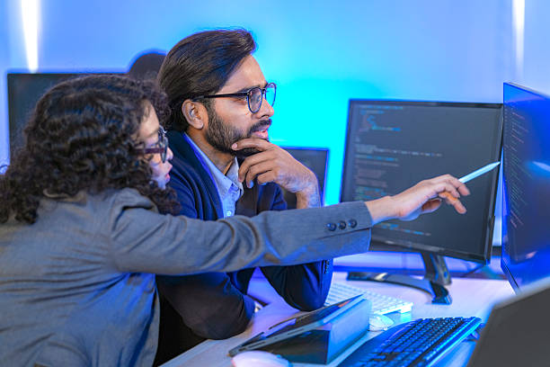 istock Diverse team of AI developers collaborating in a modern office. Indian male leading a discussion with Asian and Hispanic female colleagues on a machine learning project. 2225284575