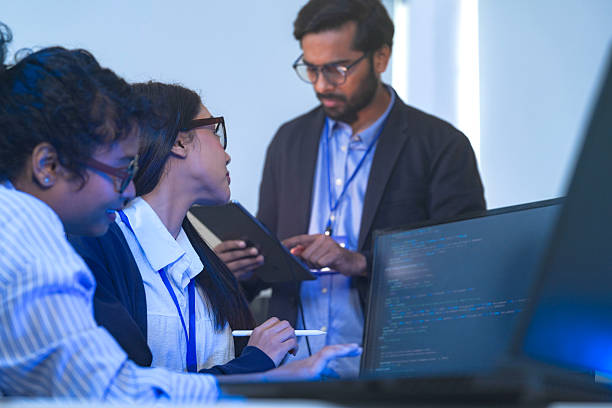 istock Diverse team of AI developers collaborating in a modern office. Indian male leading a discussion with Asian and Hispanic female colleagues on a machine learning project. 2225284811
