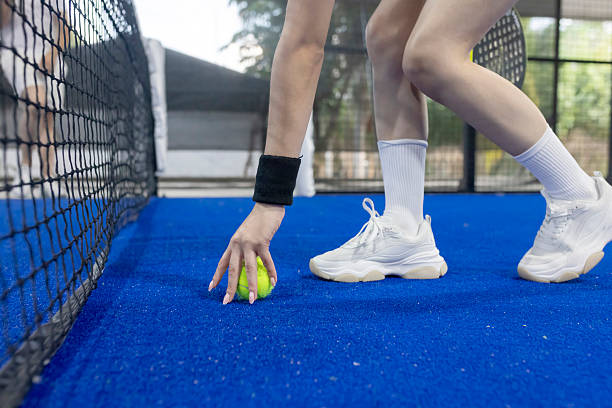 istock paddle player picking up the ball after the game 2225284830
