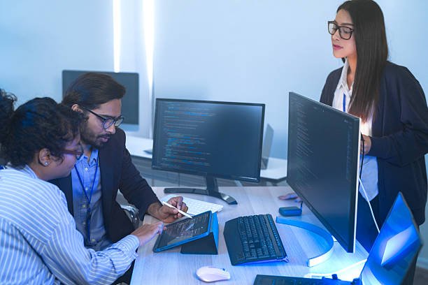istock Diverse team of AI developers collaborating in a modern office. Indian male leading a discussion with Asian and Hispanic female colleagues on a machine learning project. 2225284913
