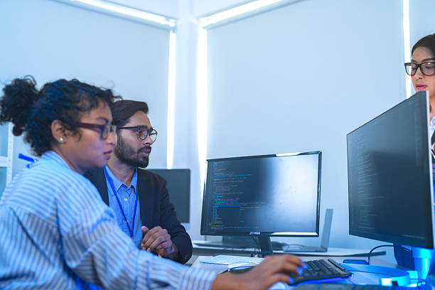 istock Diverse team of AI developers collaborating in a modern office. Indian male leading a discussion with Asian and Hispanic female colleagues on a machine learning project. 2225284973