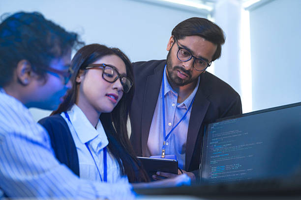 istock Diverse team of AI developers collaborating in a modern office. Indian male leading a discussion with Asian and Hispanic female colleagues on a machine learning project. 2225286777