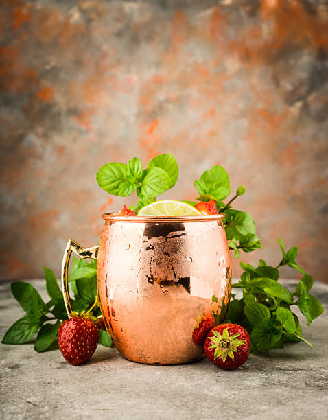 istock Refreshing Moscow mule cocktail with strawberries on the rustic background 2225290302