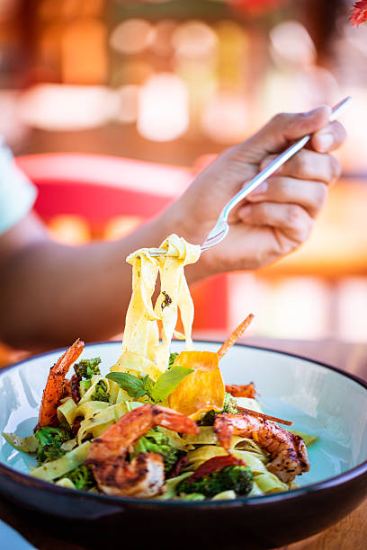 istock Male Hand Holding Fork with Fettuccini Pasta and Shrimp 2225291683