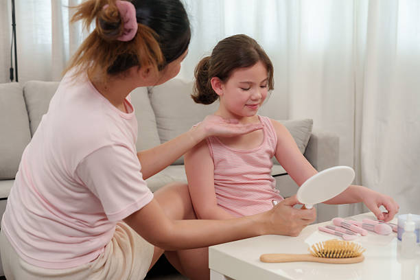 istock Asian single mother lovingly adjusting daughter's necklace while smiling at each other warmly, close affectionate moment, maternal care, trust, nurturing, joyful family connection, cozy home 2225297487