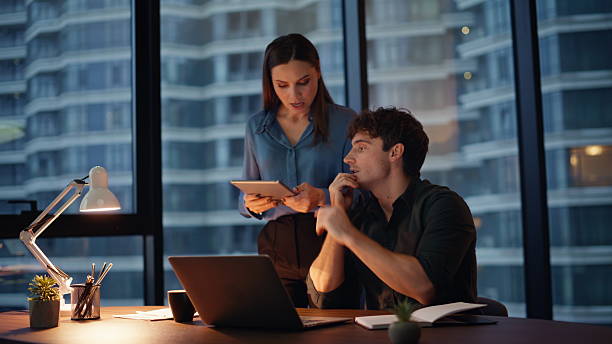 istock Videocalling managers talking webcam laptop at evening office. Two colleagues 2225297520