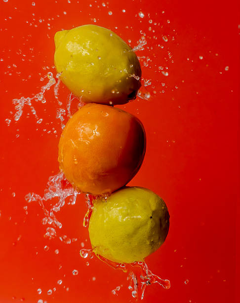 Floating Citrus Fruits Splashing Against Red Background
