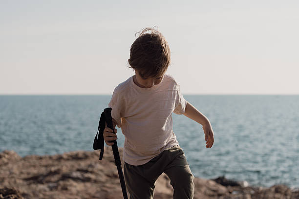istock A boy goes for a walk along the seaside to study nature resources. 2225303159