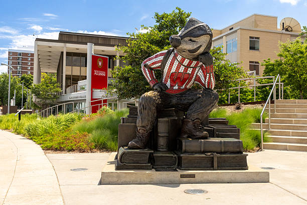 Bucky Badger statue along a walking path on Lake Mendota at the University of Wisconsin, Madison campus in Madison Wisconsin with the Alumni Center in the background.