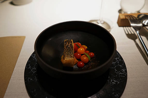 istock Close up bowl of battered and deep fried Seabass served with fresh Cherry tomatoes 2225306837