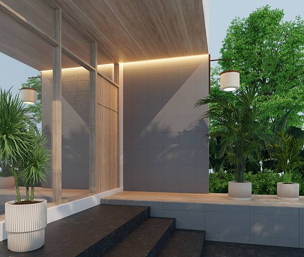 istock 3D exterior rendering of a modern minimalist building entrance. Front elevation design with wooden ceiling, grey wall tiles, recessed lighting, and potted plants. 2225307581