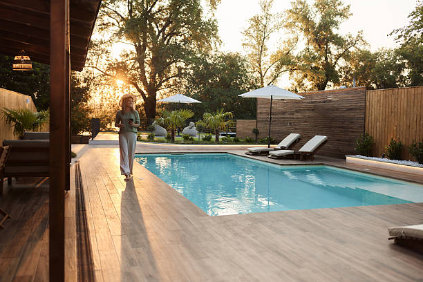 istock Happy woman using cell phone on the move by the pool at sunset. 2225309539