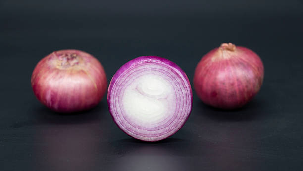 Fresh whole and slice Onion, isolated on black background