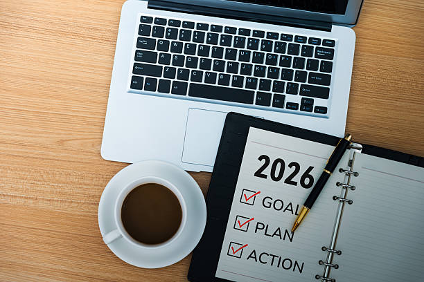 2026 new year resolutions on notepad with coffee and laptop