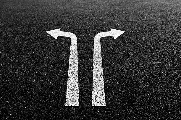 Two way arrow signs on asphalt road