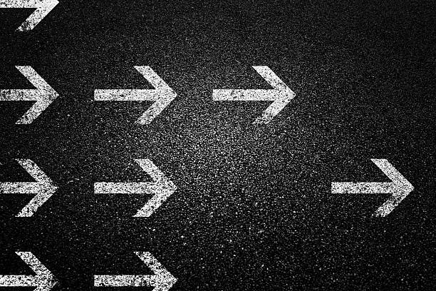 Group of arrows on black asphalt road