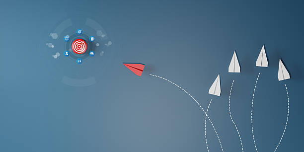 istock Red paper plane flying directly toward target among white planes going in different directions. Concept of leadership, strategy, innovation, goal focus, and business success. 2225310991