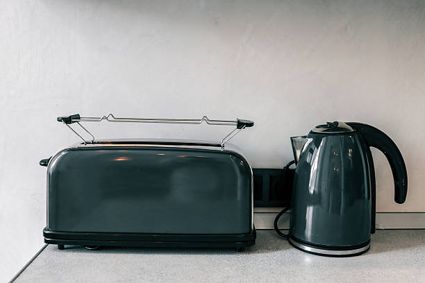 istock Modern kitchen countertop featuring matching sleek grey toaster and electric kettle against a minimalist white background. Clean, contemporary household appliances 2225316422