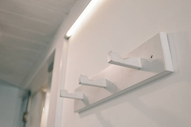 istock Minimalist white wooden wall-mounted coat rack with three hooks. Modern hallway or entryway decor highlighting simplicity and clean interior aesthetics 2225317932