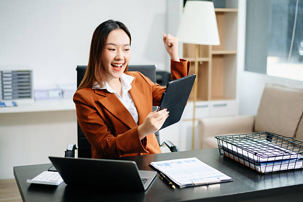 Asian working on laptops and tablets in a stylish office. Perfect for creativity, remote work, modern lifestyle, and startup themes.