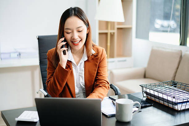 Asian working on laptops and tablets in a stylish office. Perfect for creativity, remote work, modern lifestyle, and startup themes.