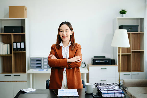 istock Asian female office worker business suits smiling at camera with working notepad, tablet and laptop documents in office 2225318144