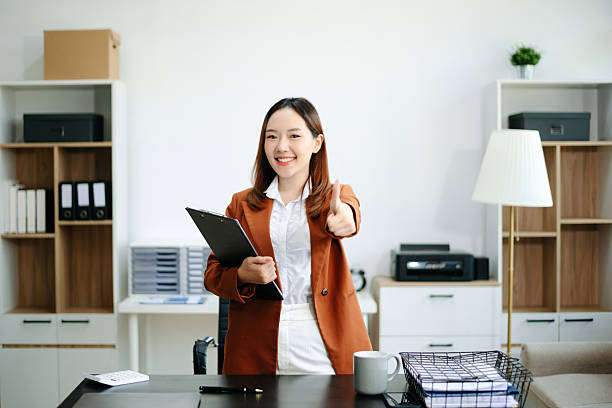 Asian working on laptops and tablets in a stylish office. Perfect for creativity, remote work, modern lifestyle, and startup themes.