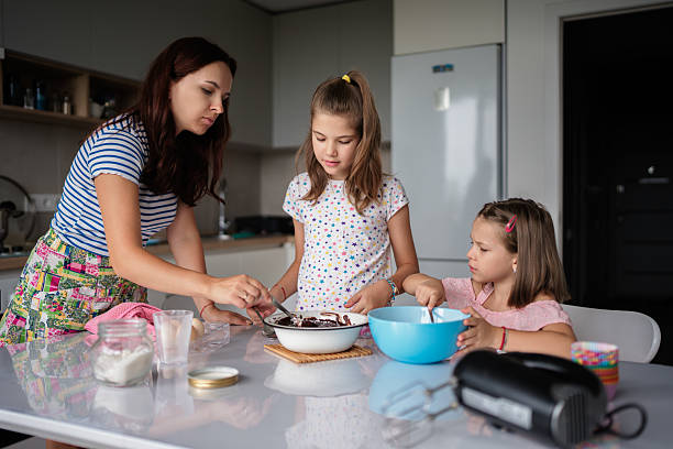 istock Mother and daughters baking together in the kitchen 2225319448