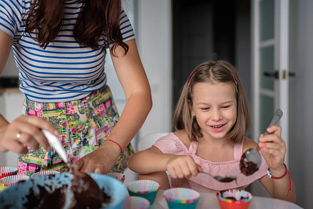 istock Mother and daughter making cupcakes together in the kitchen 2225319506
