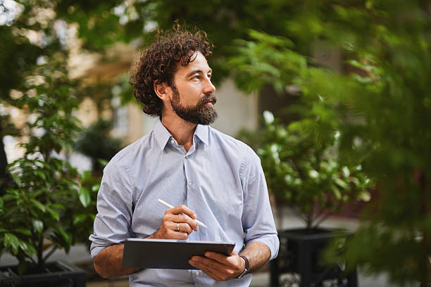 istock Confident businessman working with digital tablet outdoors and looking away 2225320148