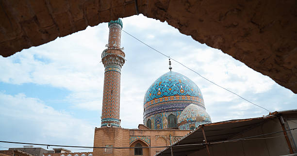 Stunning Baghdad mosque with detailed tile work and tall minaret under clouds